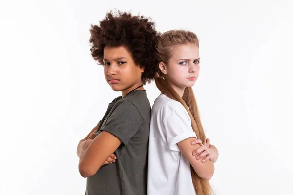 Angry upset kids standing back to back with crossed hands — Stock Photo, Image