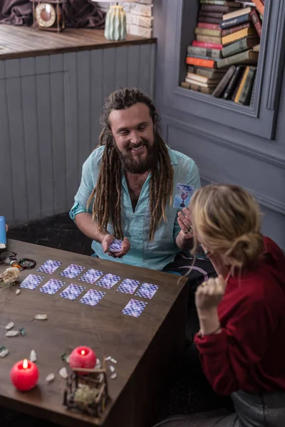 Top view of a positive bearded man with tarot cards