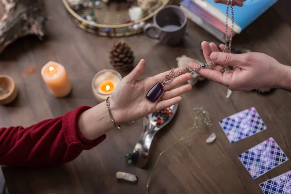 Vista dall'alto di una mano femminile che prende la collana — Foto Stock