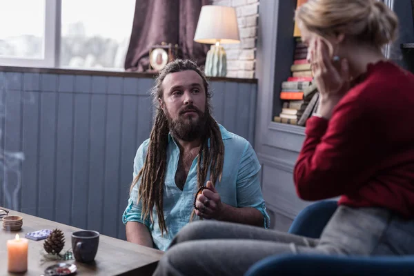 Serious bearded fortune teller looking at his client — Stock Photo, Image