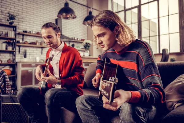 Muzikant met bob gesneden toetreding tot zijn vriend gitaar spelen — Stockfoto