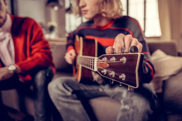 Close up van blonde-haired musicus gitaarspelen thuis — Stockfoto