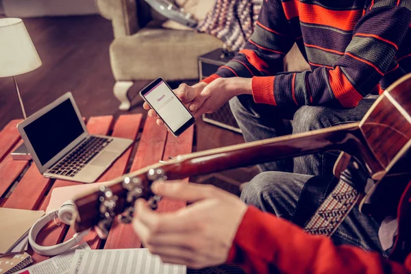 Close-up van twee muzikanten zoeken voor sommige melodie in het Internet — Stockfoto