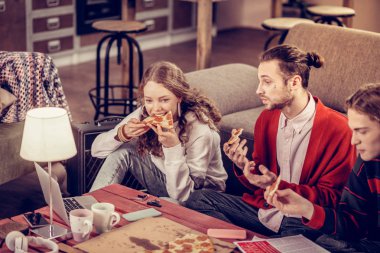 Kız parça salamlı pizza arkadaşlarıyla birlikte öğle yemeği yeme