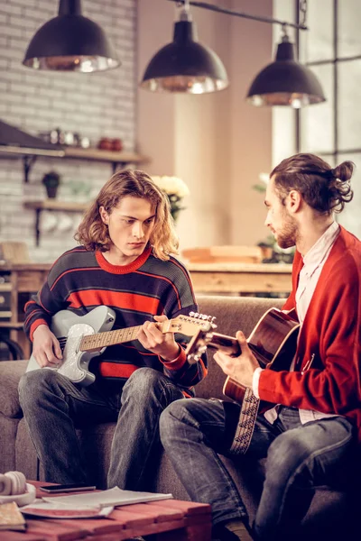 Studenten dragen van jeans gevoel die betrokken zijn bij het gitaarspelen samen — Stockfoto