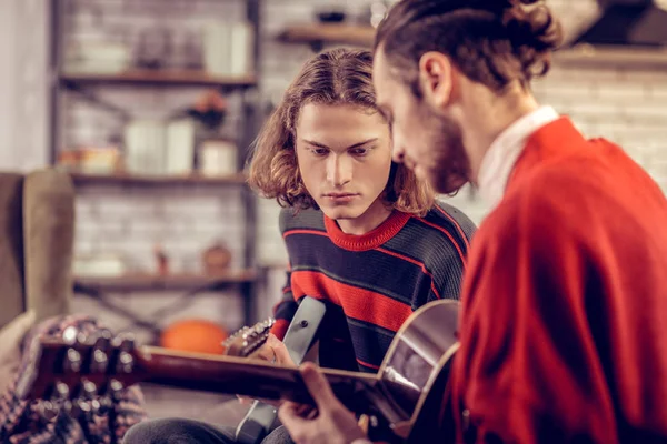 Knappe blonde-haired man, gitaarspelen met broer — Stockfoto