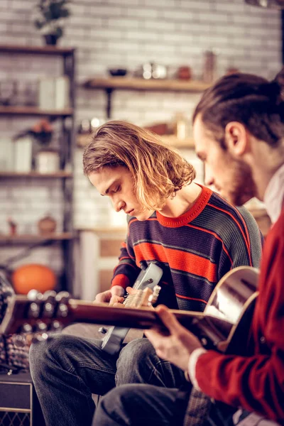 Twee knappe getalenteerde jonge mannen die een goed gitaarspelen gevoel — Stockfoto