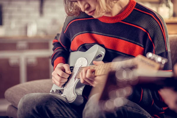 Estudiante creativo sosteniendo su guitarra y componiendo melodía — Foto de Stock