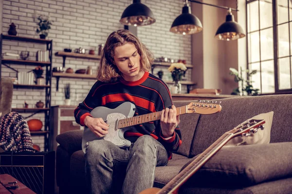 Student in Jeans spielt Gitarre und komponiert Melodie — Stockfoto