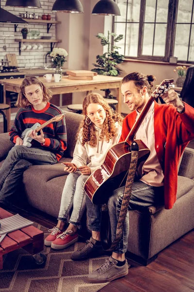 Music band feeling excited while having rehearsal at home