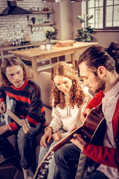 Curly girl gevoel vreugdevolle luisteren naar haar vriend de gitaar spelen — Stockfoto