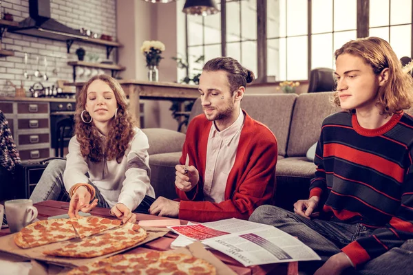 Dois irmãos e irmã comendo pizza com salame depois de tocar guitarra — Fotografia de Stock