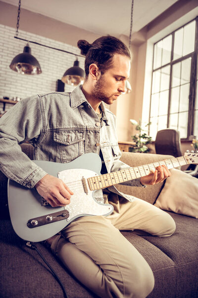 Bearded musician wearing denim shirt composing new song