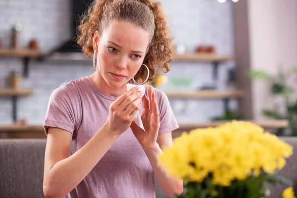 Disturb good-looking curly girl using napkin for teardrops