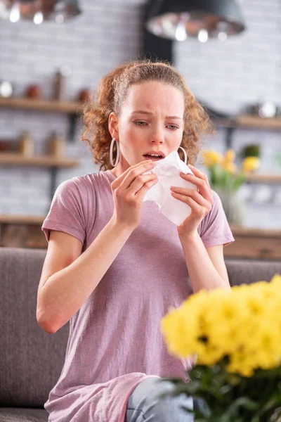 Senhora de cabelos compridos angustiada espirrando por causa de alergia — Fotografia de Stock