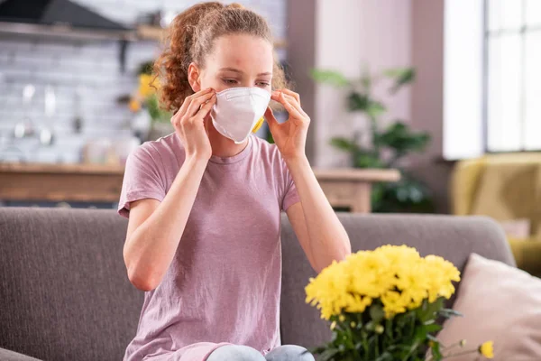 Resolute long-haired woman wearing special mask while suffering — Stock Photo, Image