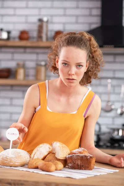 Aantrekkelijk curly-haired meisje met allergie op gluten bevatte in brood — Stockfoto