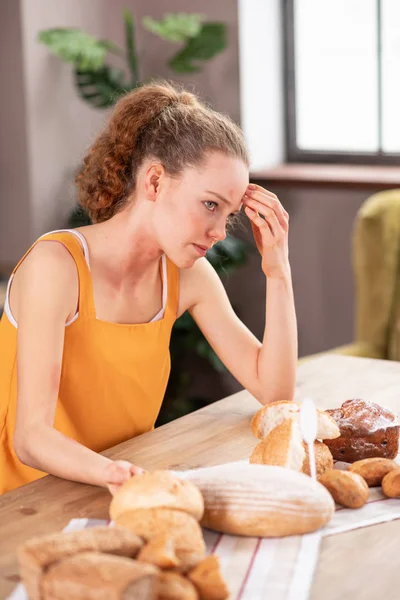 Annoyed long-haired girl in yellow apron suffering from allergy — Stock Photo, Image