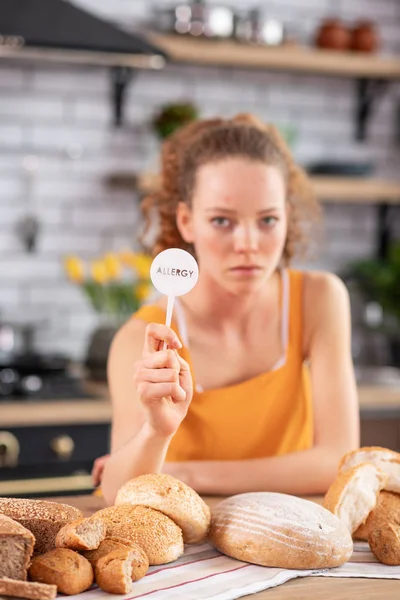 Chica infeliz decidida mostrando placa blanca en su mano — Foto de Stock