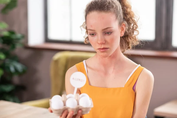 Perturb long-haired attractive girl having allergic reaction on eggs — Stock Photo, Image