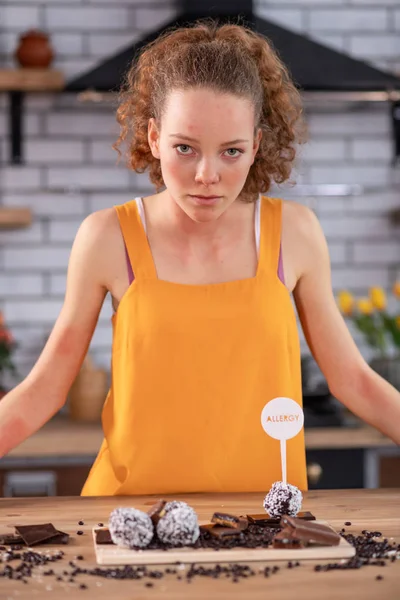 Nieuwsgierig langharige vrouw met lichte ogen aandachtig kijken op snoep — Stockfoto