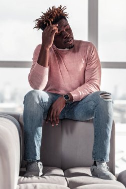 Ciddi sakallı genç adam alnına dokunmak