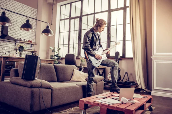 Muzikant zijn been op tafel zetten tijdens het spelen van rocknummer — Stockfoto