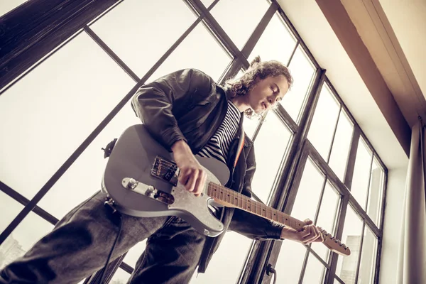 Músico con jeans y chaqueta de cuero negro tocando la guitarra — Foto de Stock