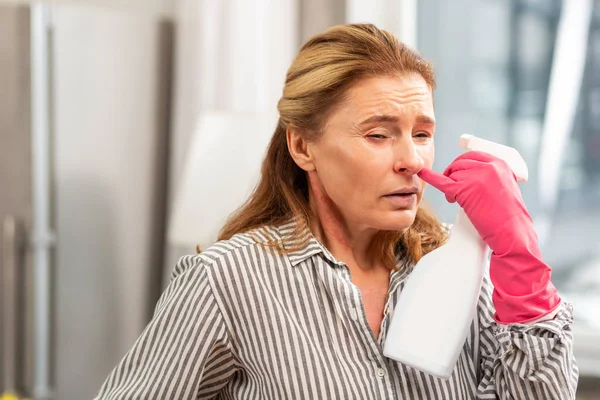 Rijpe vrouw niezen na het gebruik van chemische stoffen voor het reinigen — Stockfoto