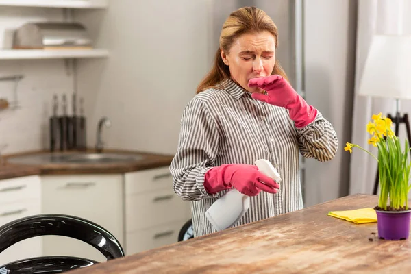Ama de casa limpiando la cocina estornudando mientras tiene alergia — Foto de Stock