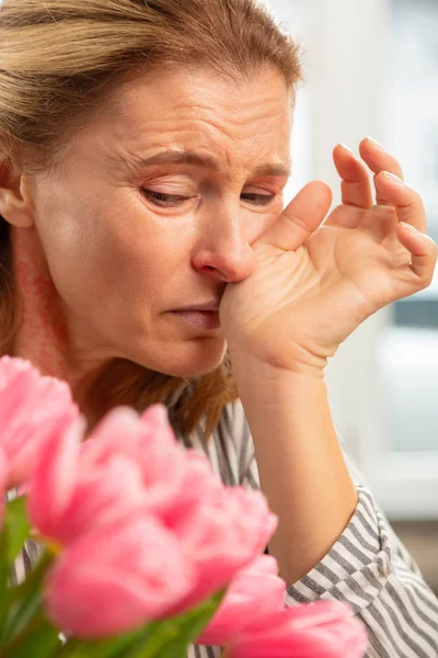 Mulher madura sentindo-se horrível depois de receber flores de amado — Fotografia de Stock