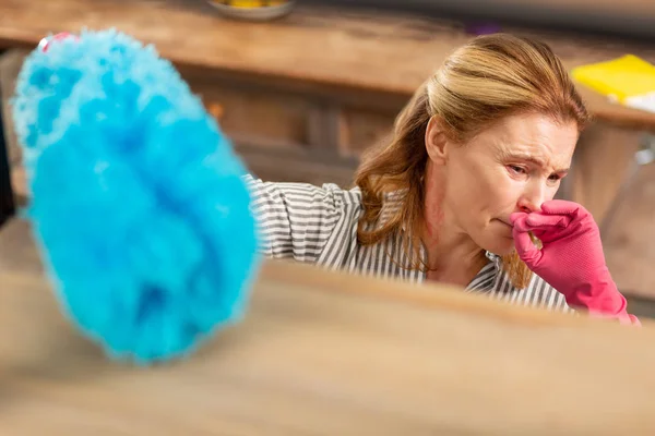 Dark-eyed woman wearing pink gloves having allergy to dust — Stock Photo, Image