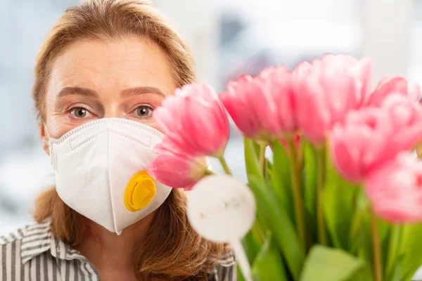 Mature woman wearing protective mask because of allergy — Stock Photo, Image