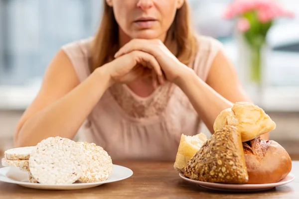 Nő az allergia közötti választás chips és a kenyér — Stock Fotó