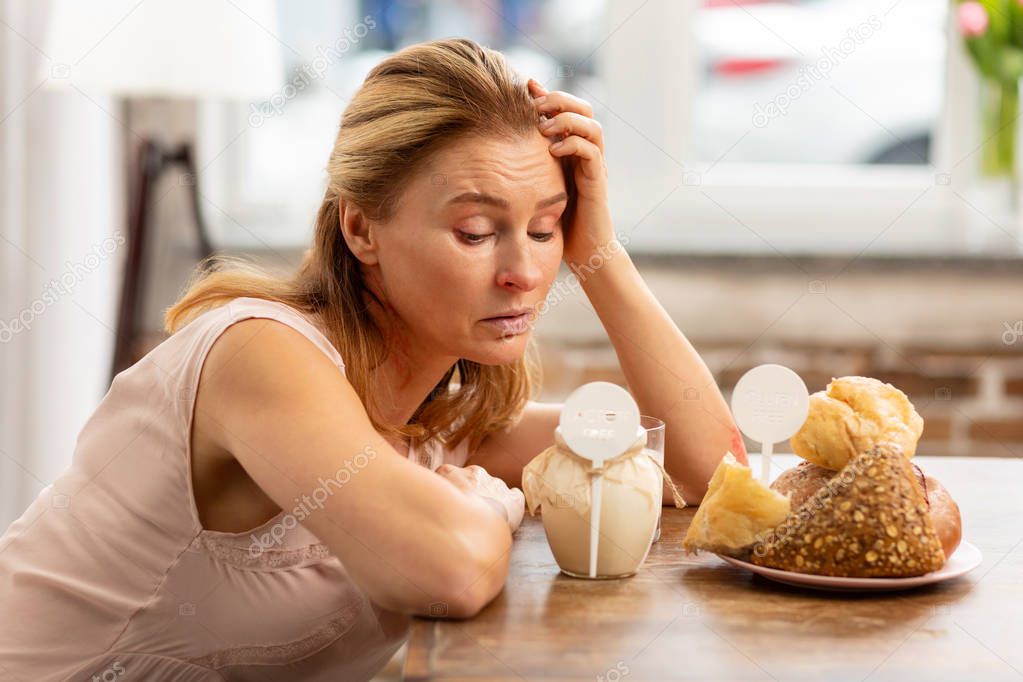 Woman looking at dairy and pastry products having strong allergy