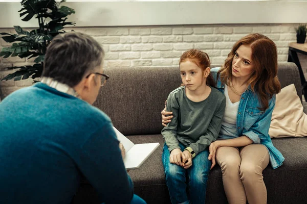 Trieste vrolijke meisje zitten met haar moeder — Stockfoto