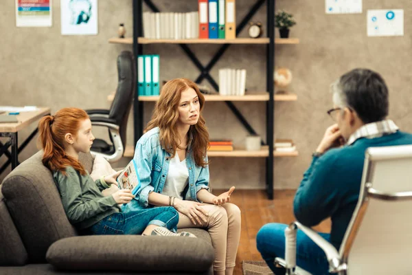 Mujer joven agradable teniendo una conversación con su terapeuta — Foto de Stock