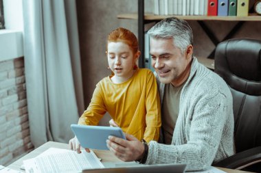 Tablet ekrana bakarak olumlu neşeli adam