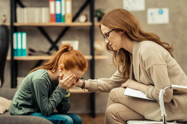 Unglücklich angenehmes junges Mädchen, das ihr Gesicht bedeckt — Stockfoto