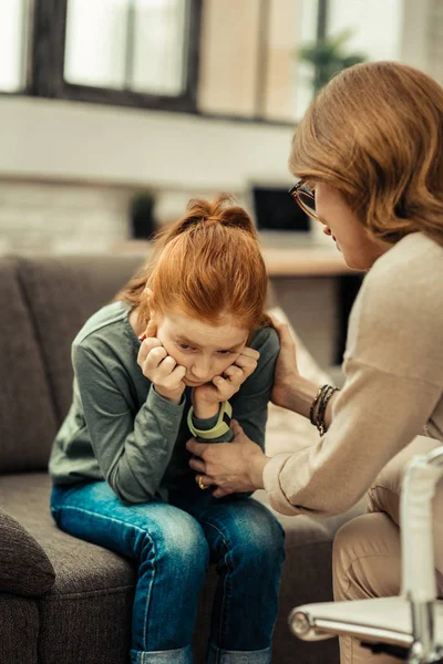 Deprimiertes, trauriges rothaariges Mädchen, das ihre Wangen hält — Stockfoto