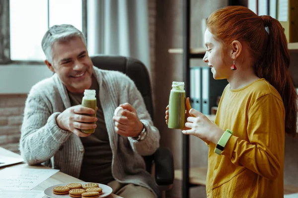 Alegre chica feliz sosteniendo una botella con jugo —  Fotos de Stock