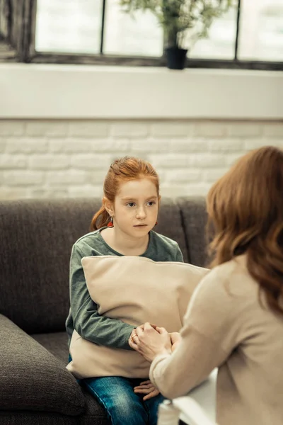 Безвесела молода дівчина сидить навпроти свого терапевта — стокове фото