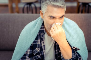 Mutsuz hasta adam bir doku ile burnunu silerek