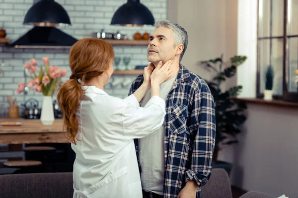 Médico profesional femenino tocando el cuello de sus pacientes — Foto de Stock