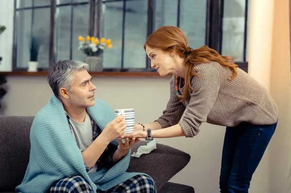 Positive fröhliche Frau bringt Tee für ihren Mann — Stockfoto