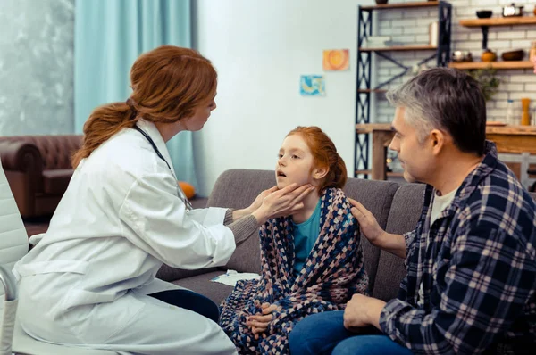 Miły profesjonalny lekarz dotykając jej pacjentów szyi — Zdjęcie stockowe