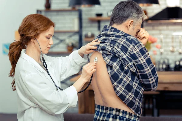 Niza médico serio usando su estetoscopio profesional — Foto de Stock