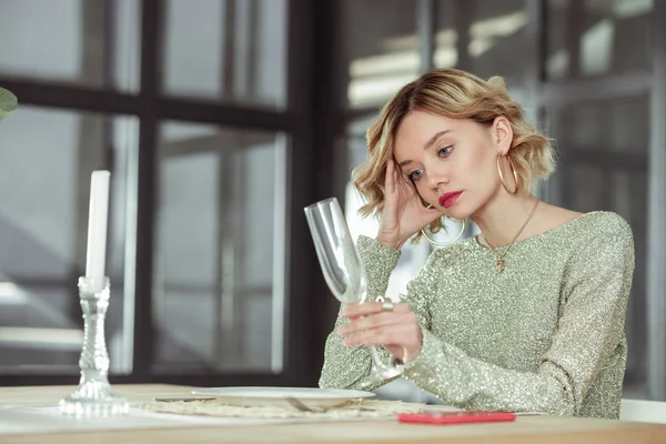 Wife looking at empty glass waiting for husband from work — Stock Photo, Image