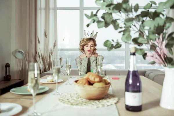 Schöne Geburtstagsfrau, die ohne Gäste am Tisch sitzt — Stockfoto