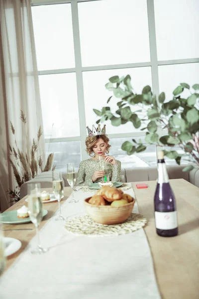 Birthday woman not having good mood sitting alone at the table — Stock Photo, Image